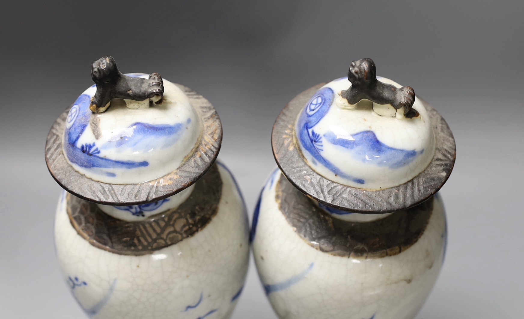 A pair of early 20th century Chinese blue and white crackle glaze vases and covers, 30cm